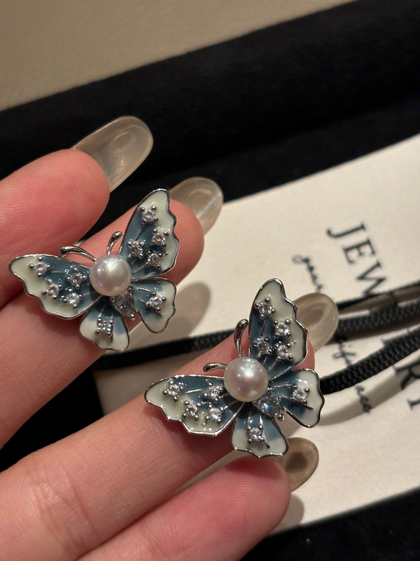 Close-up of blue butterfly wings with freshwater pearl drop