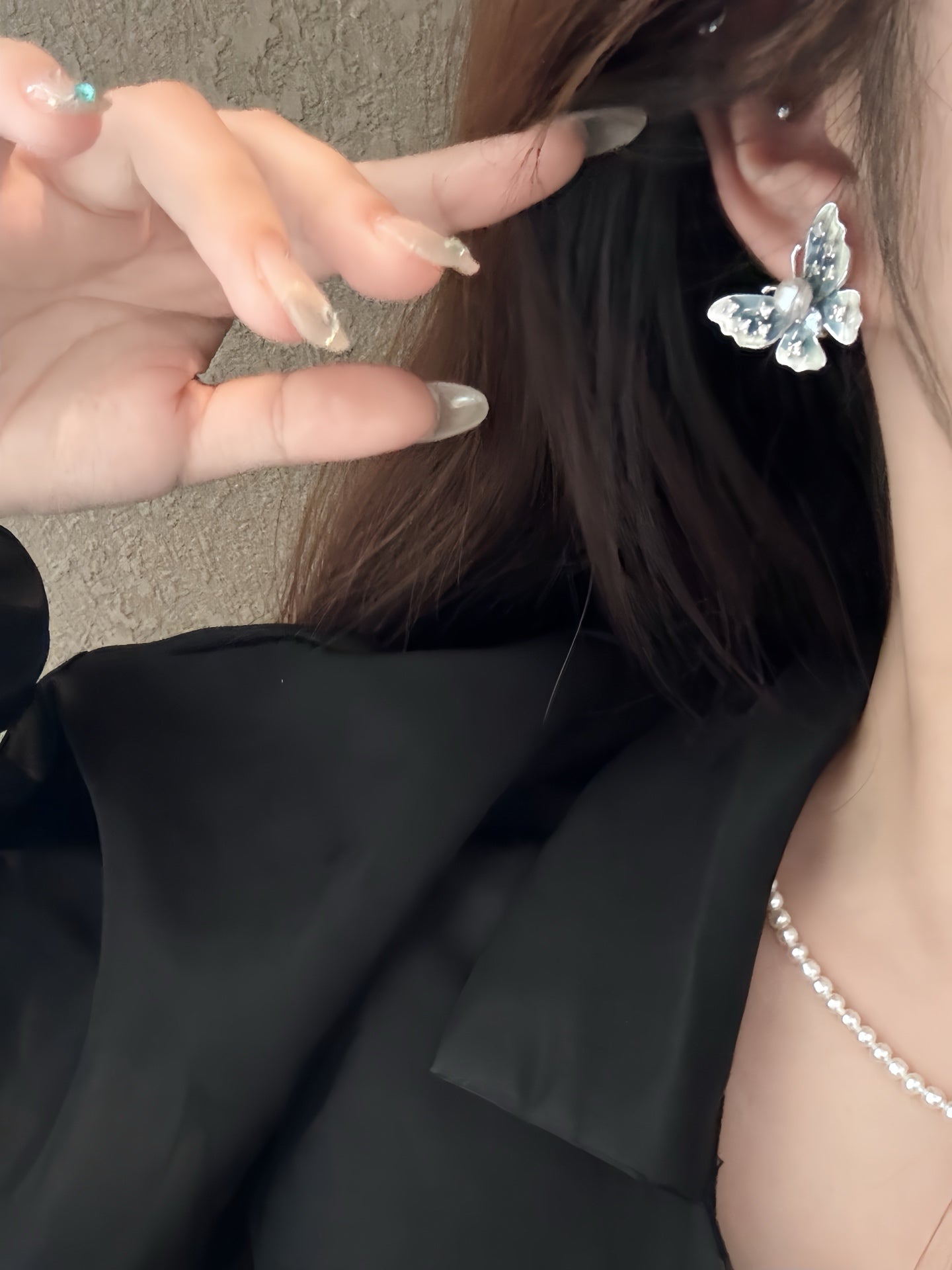 Model wearing artistic enamel butterfly pearl earrings