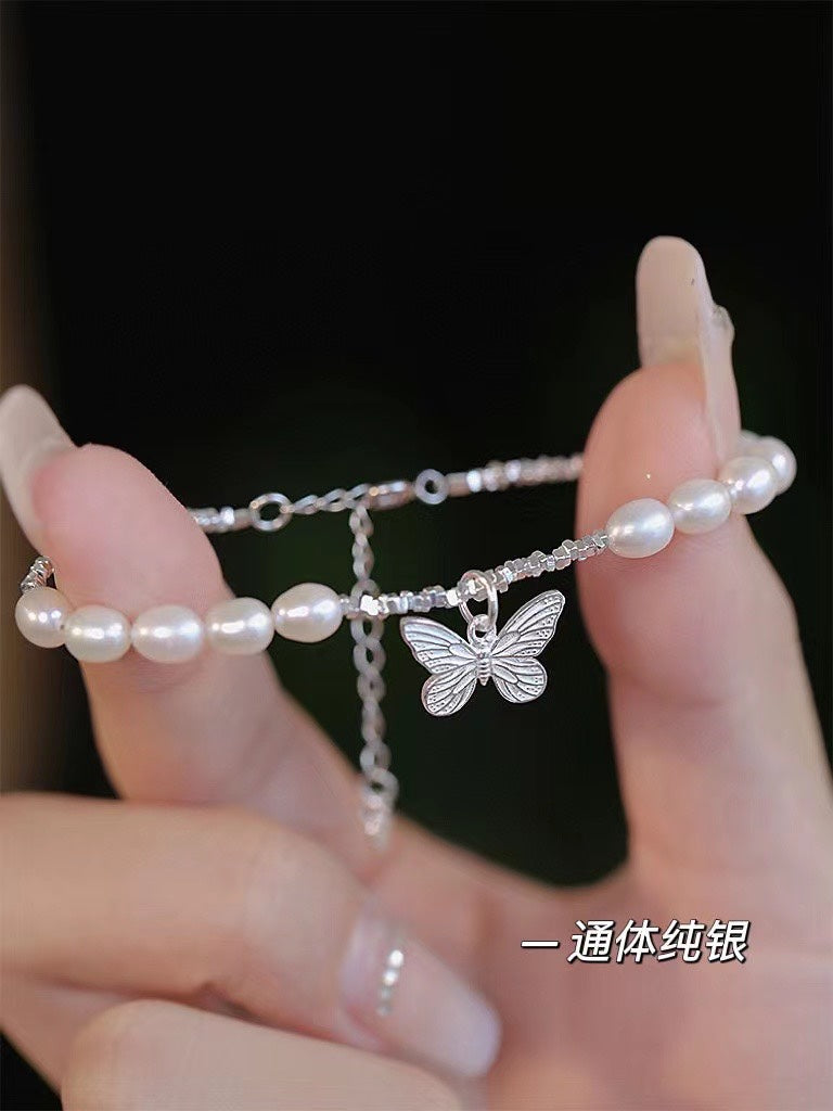 Close-up of freshwater pearls and poetic butterfly charm