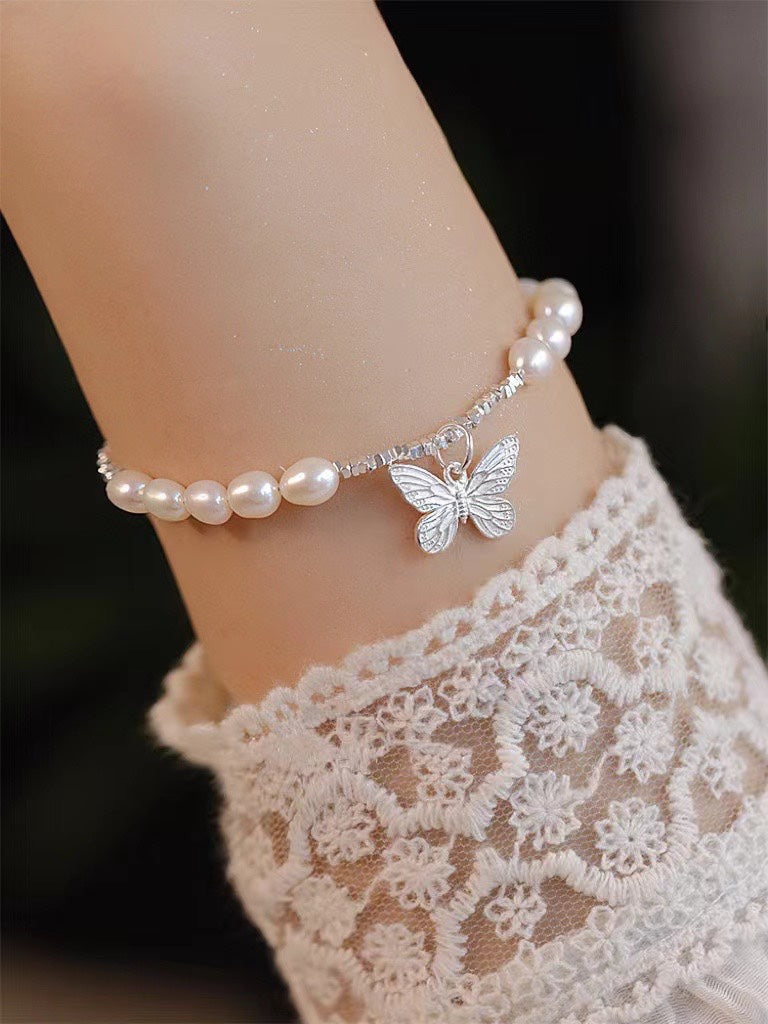 Close-up of freshwater pearls and poetic butterfly charm