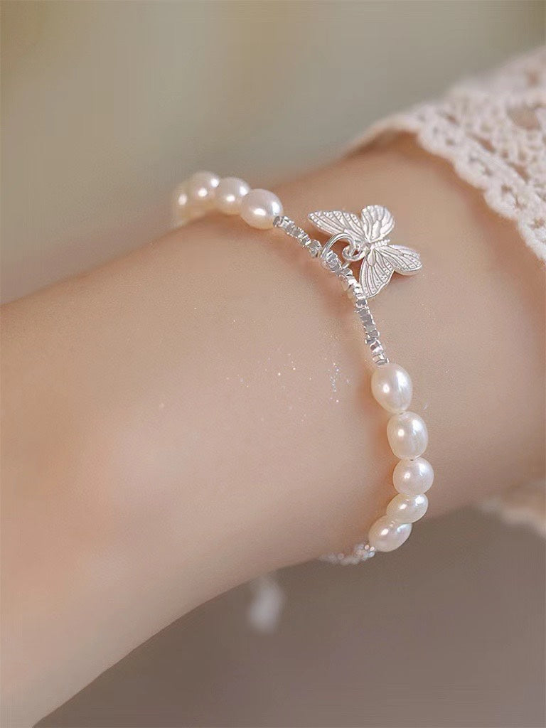 Close-up of freshwater pearls and poetic butterfly charm