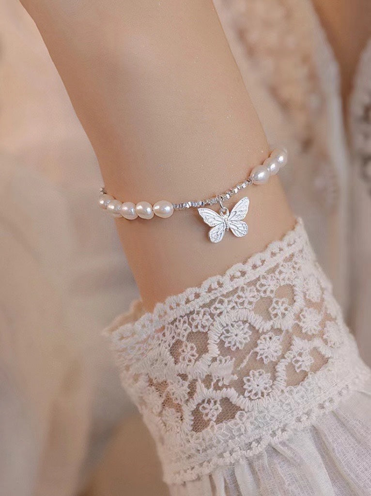 Close-up of freshwater pearls and poetic butterfly charm