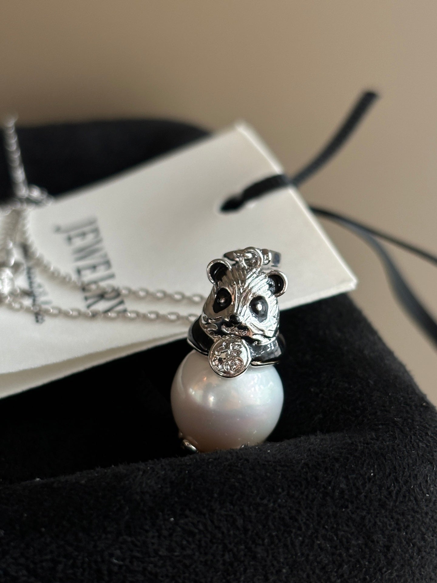 Close-up of high-luster Edison pearl and panda charm