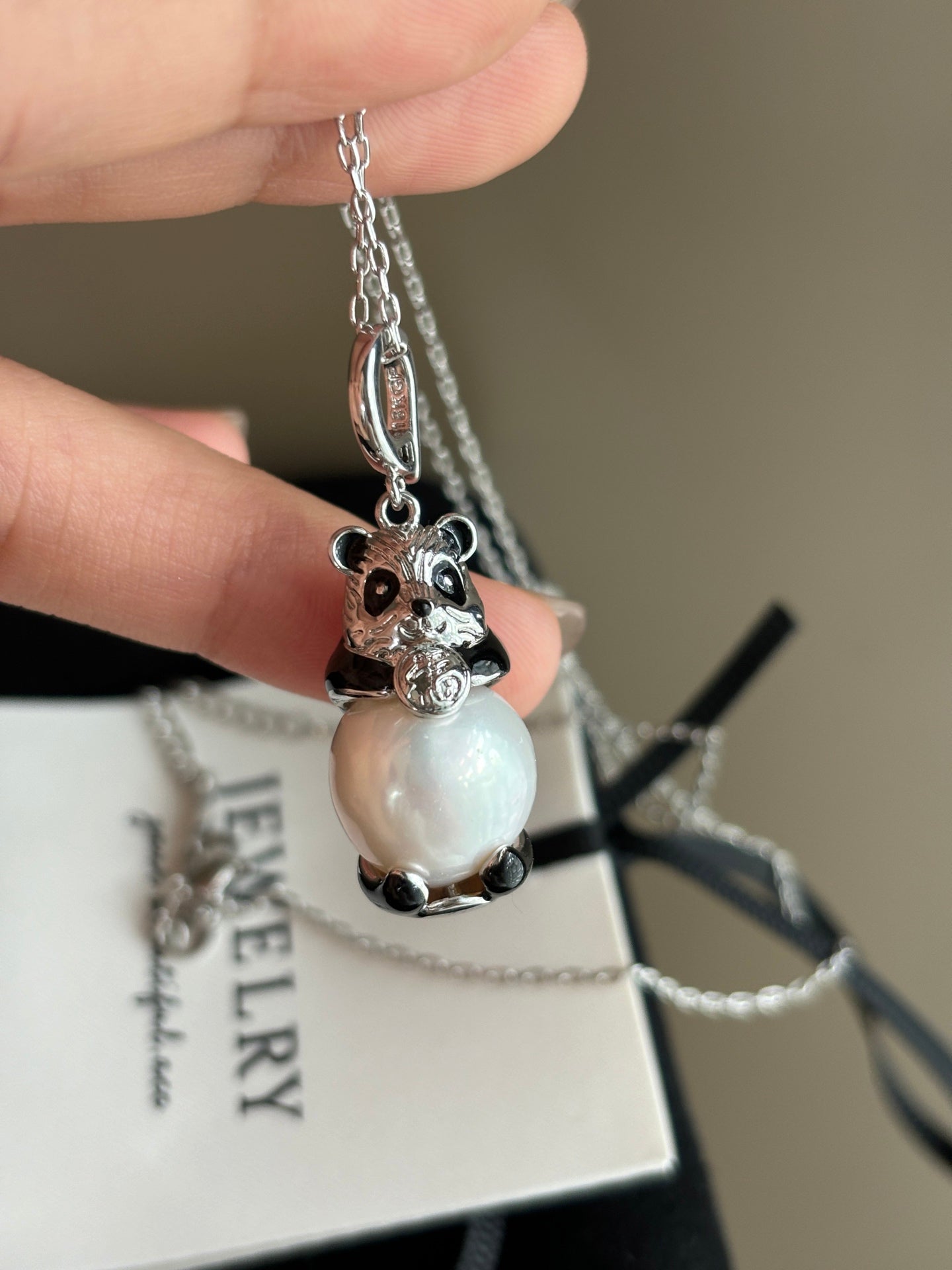 Close-up of high-luster Edison pearl and panda charm