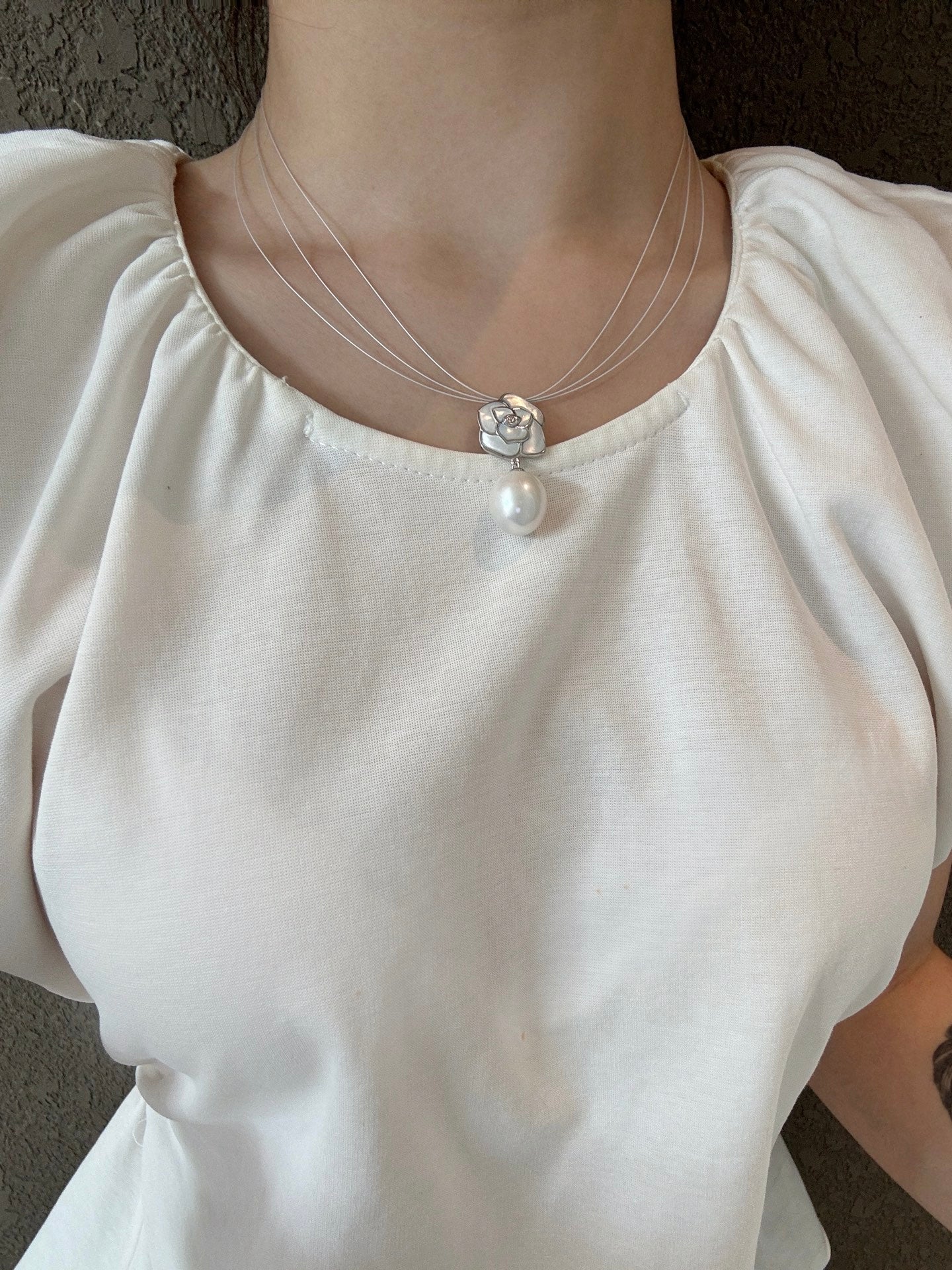 Model wearing feminine camellia pearl choker necklace