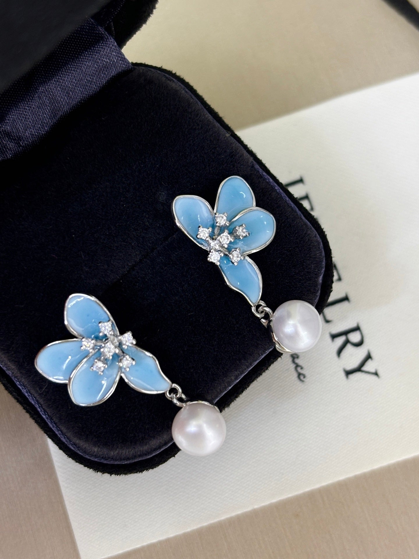 Blue petal stud earrings with freshwater pearl center