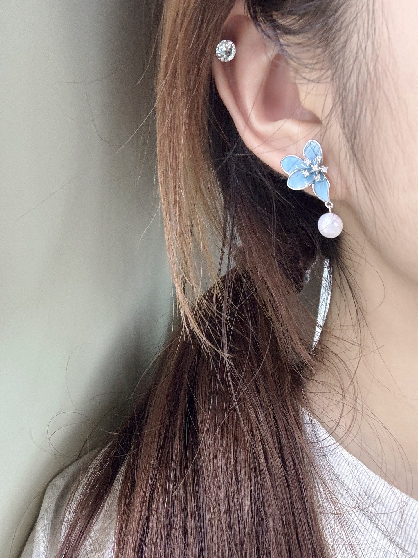 Model wearing blue floral pearl earrings