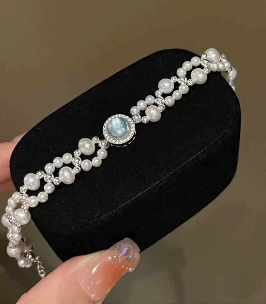Close-up of 3–6mm lustrous pearls with silver weaving and aquamarine beads