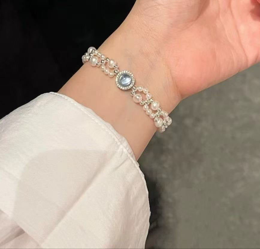 Model wearing ocean-inspired pearl and aquamarine bracelet