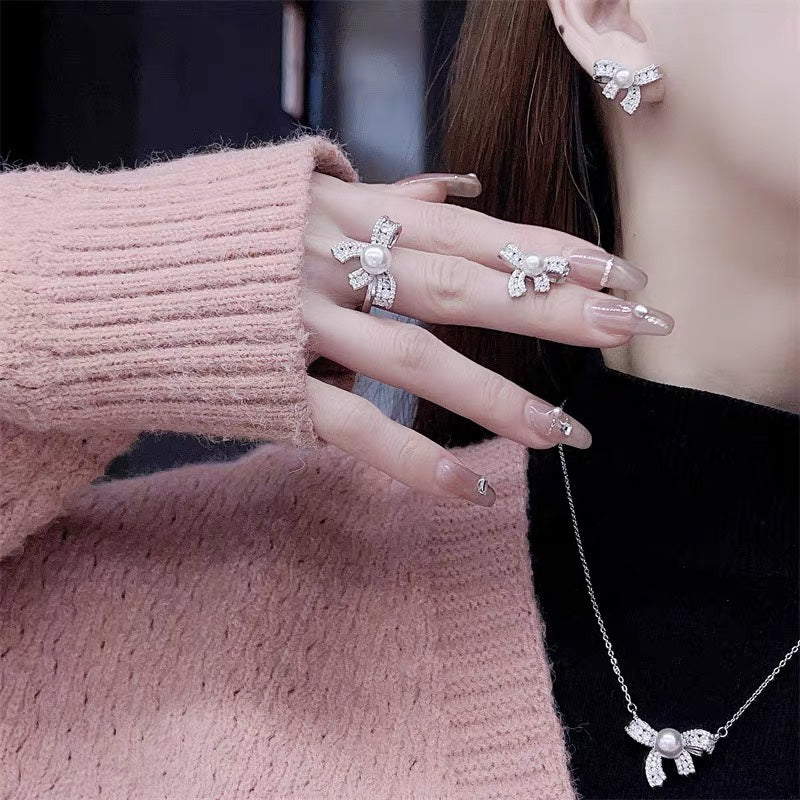 Close-up of dazzling bow pearl necklace, earrings, and ring