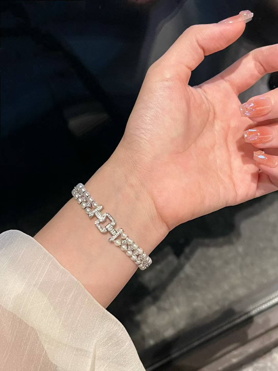 Model wearing high jewelry pearl bracelet with ornate clasp