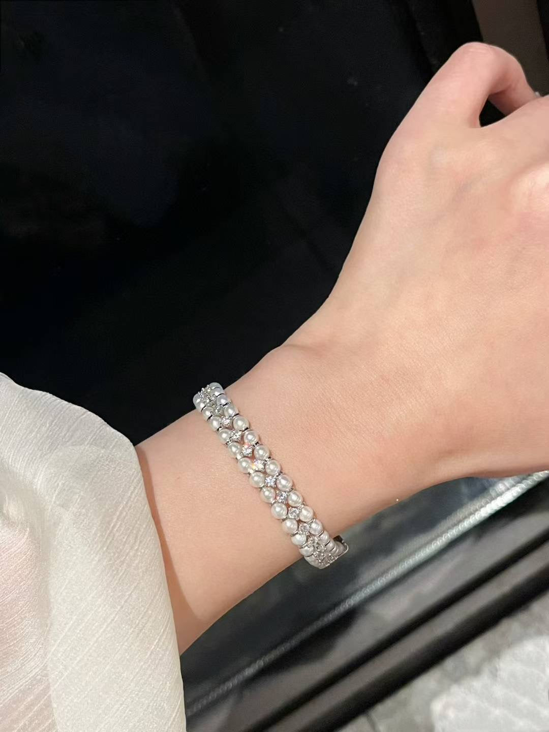 Model wearing high jewelry pearl bracelet with ornate clasp