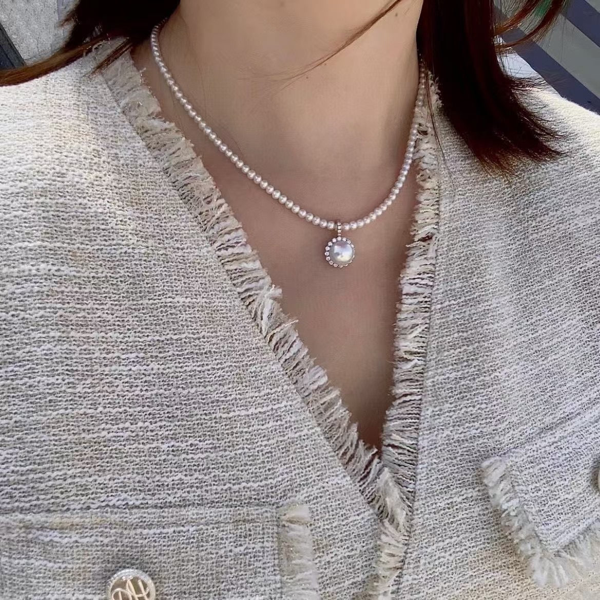 Model wearing minimalist pearl necklace with removable pendant
