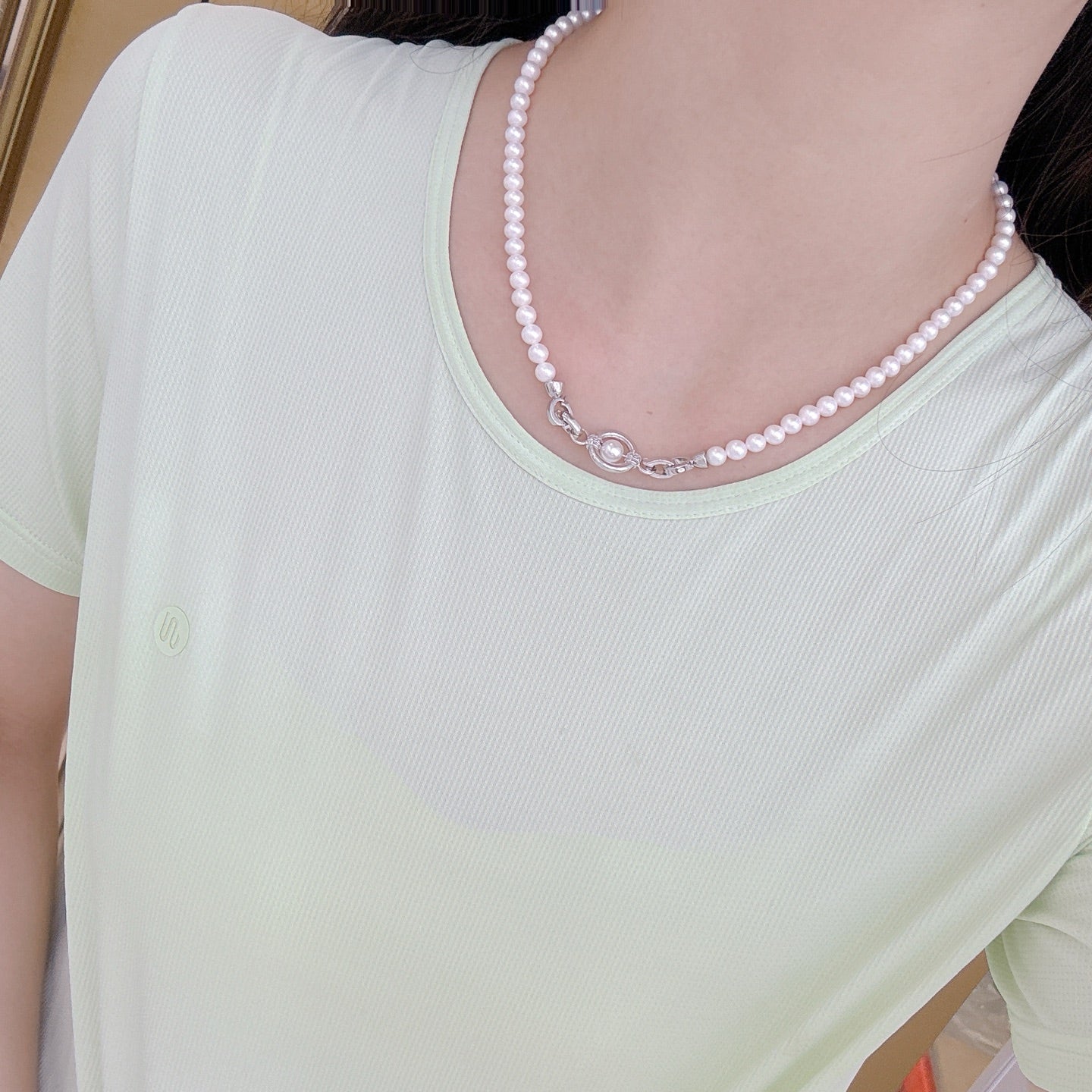 Model wearing adjustable-length pearl necklace