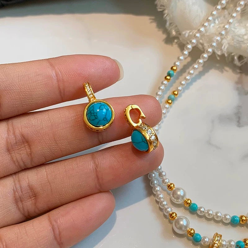 Close-up of a baby pearl necklace with 3–4mm freshwater pearls and a gold-filled charm pendant featuring a universal clasp.