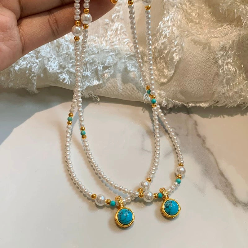 Close-up of a baby pearl necklace with 3–4mm freshwater pearls and a gold-filled charm pendant featuring a universal clasp.