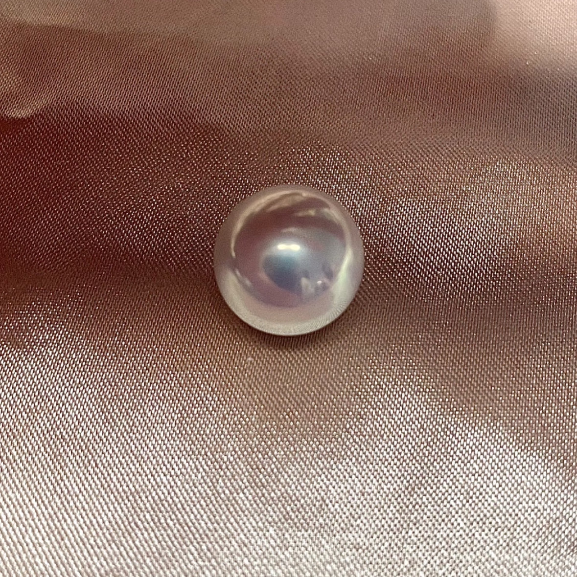 Close-up of a cool white, round Edison freshwater pearl with high luster
