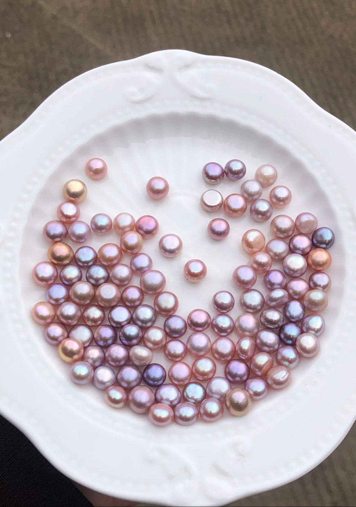 Close-up of 8–9mm lavender freshwater button pearl stud earrings on a white velvet tray