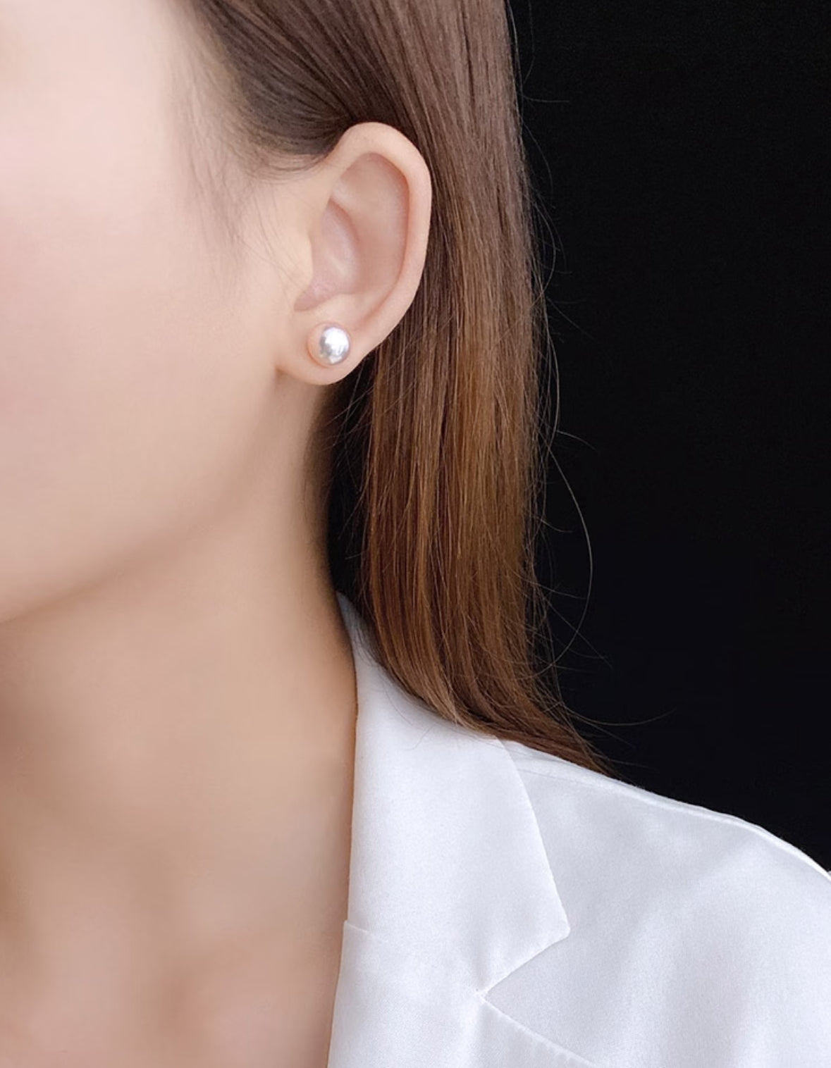 Close-up of luminous Akoya pearl stud earrings set in 18K gold