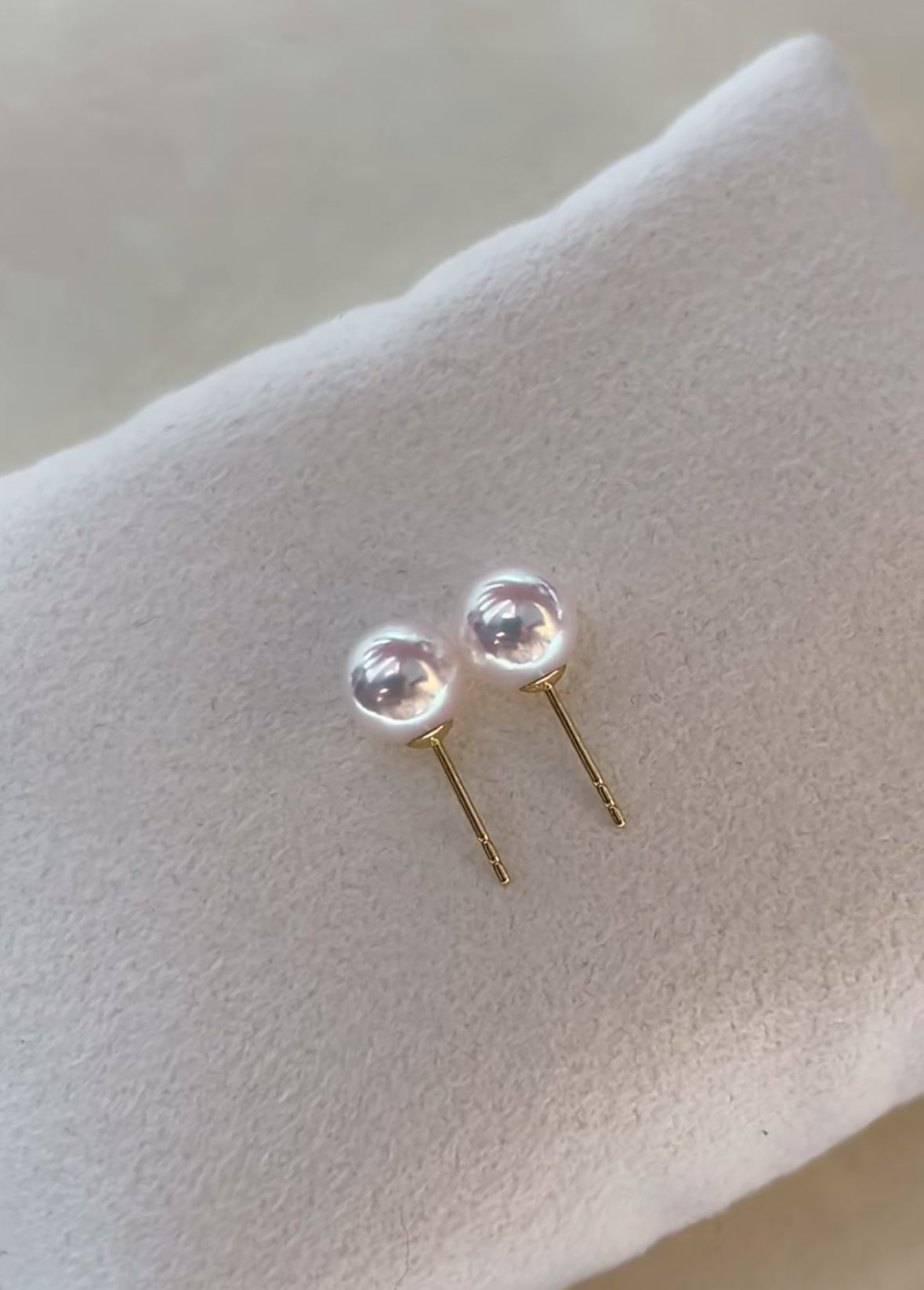Close-up of luminous Akoya pearl stud earrings set in 18K gold