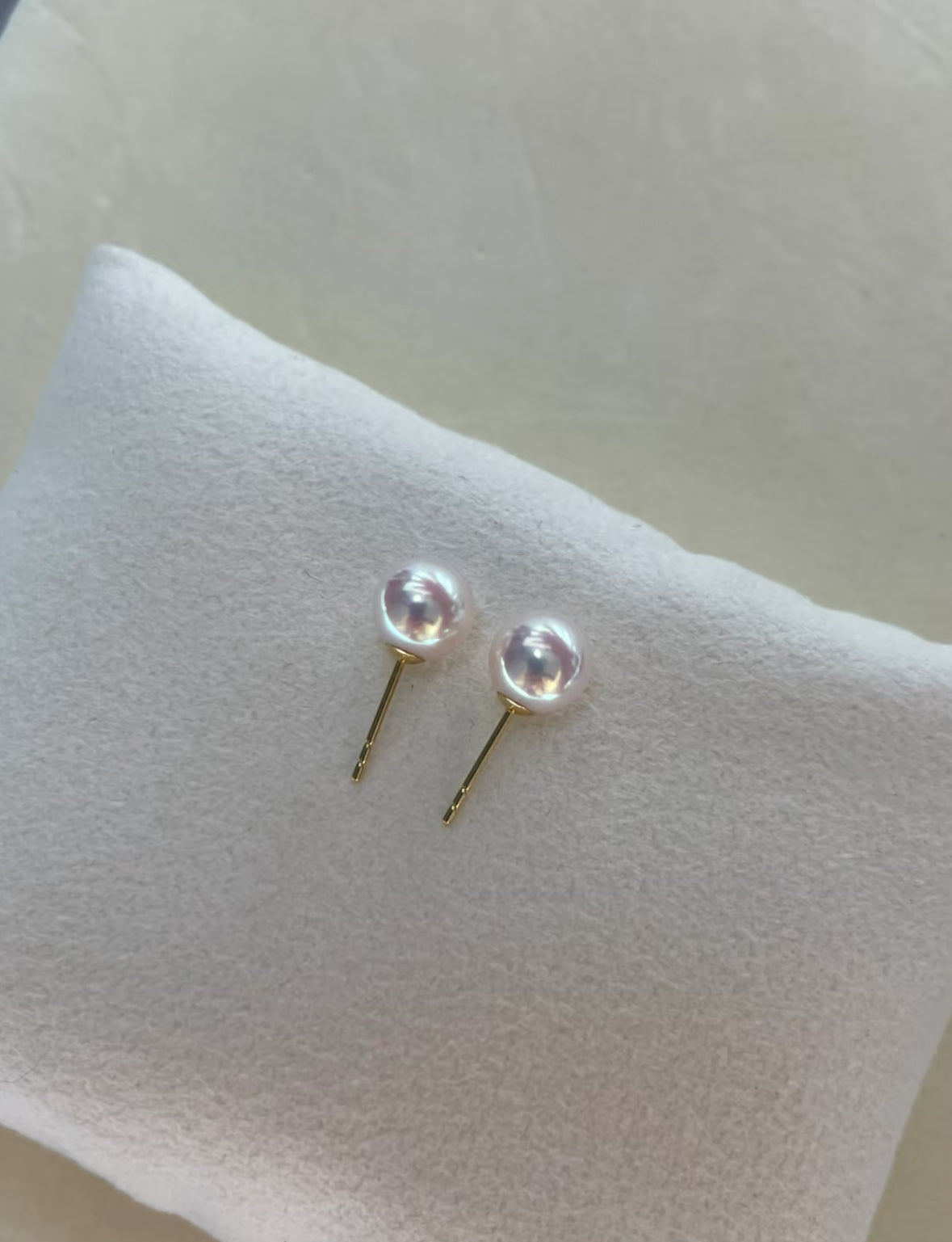 Close-up of luminous Akoya pearl stud earrings set in 18K gold