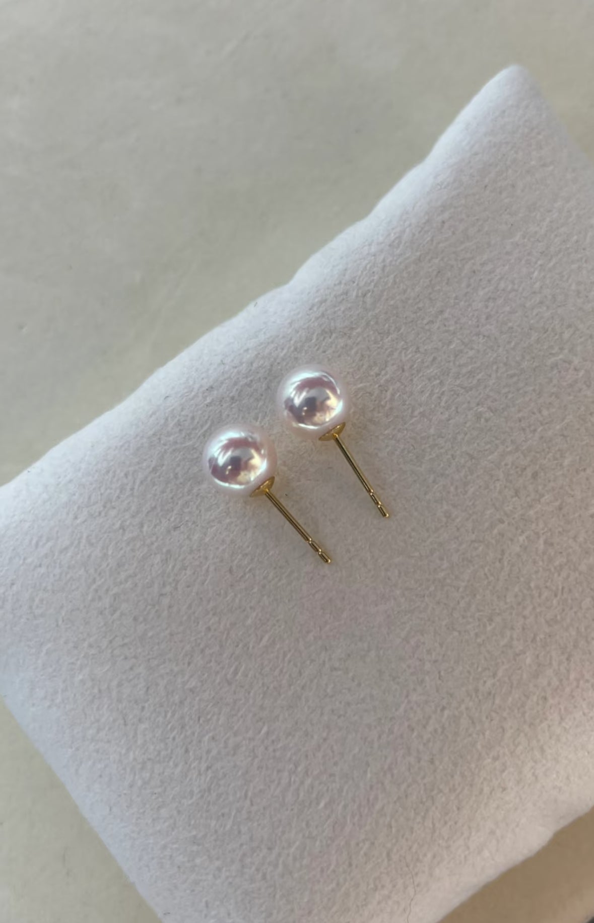 Close-up of luminous Akoya pearl stud earrings set in 18K gold
