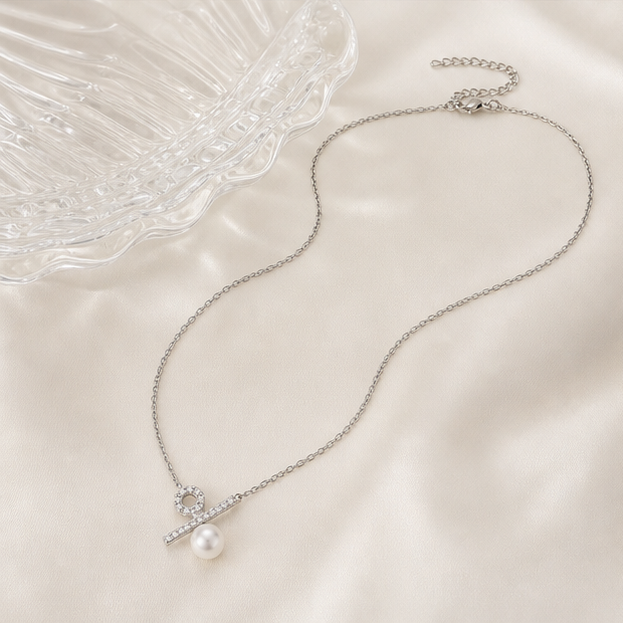 Ratio – Minimalist Pearl Percentage Necklace in a product-only clear glass still life