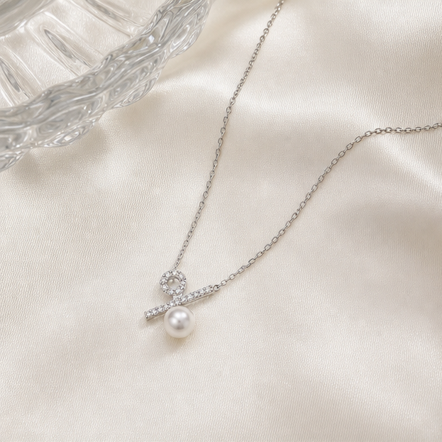 Ratio – Minimalist Pearl Percentage Necklace photographed on ivory satin