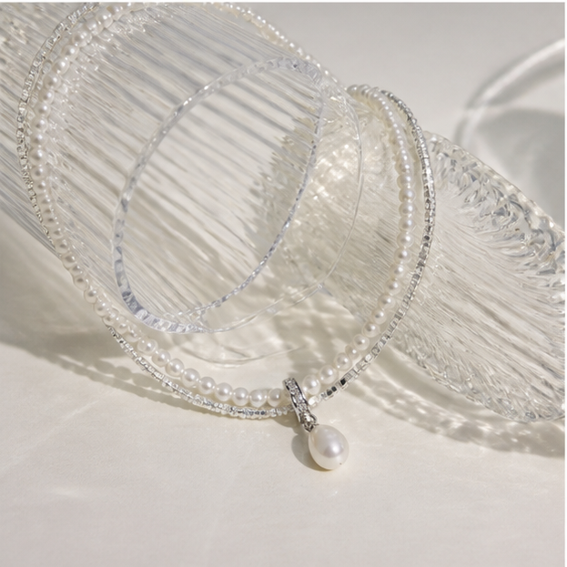 Double-Layer Sterling Silver Pearl Necklace – Drop Pearl & Baby Pearl Shine in a product-only clear glass still life