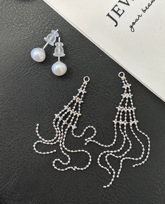 Asymmetric tassel earrings with 7–8mm freshwater pearls and sterling silver posts, featuring a dewdrop-inspired flowing design.