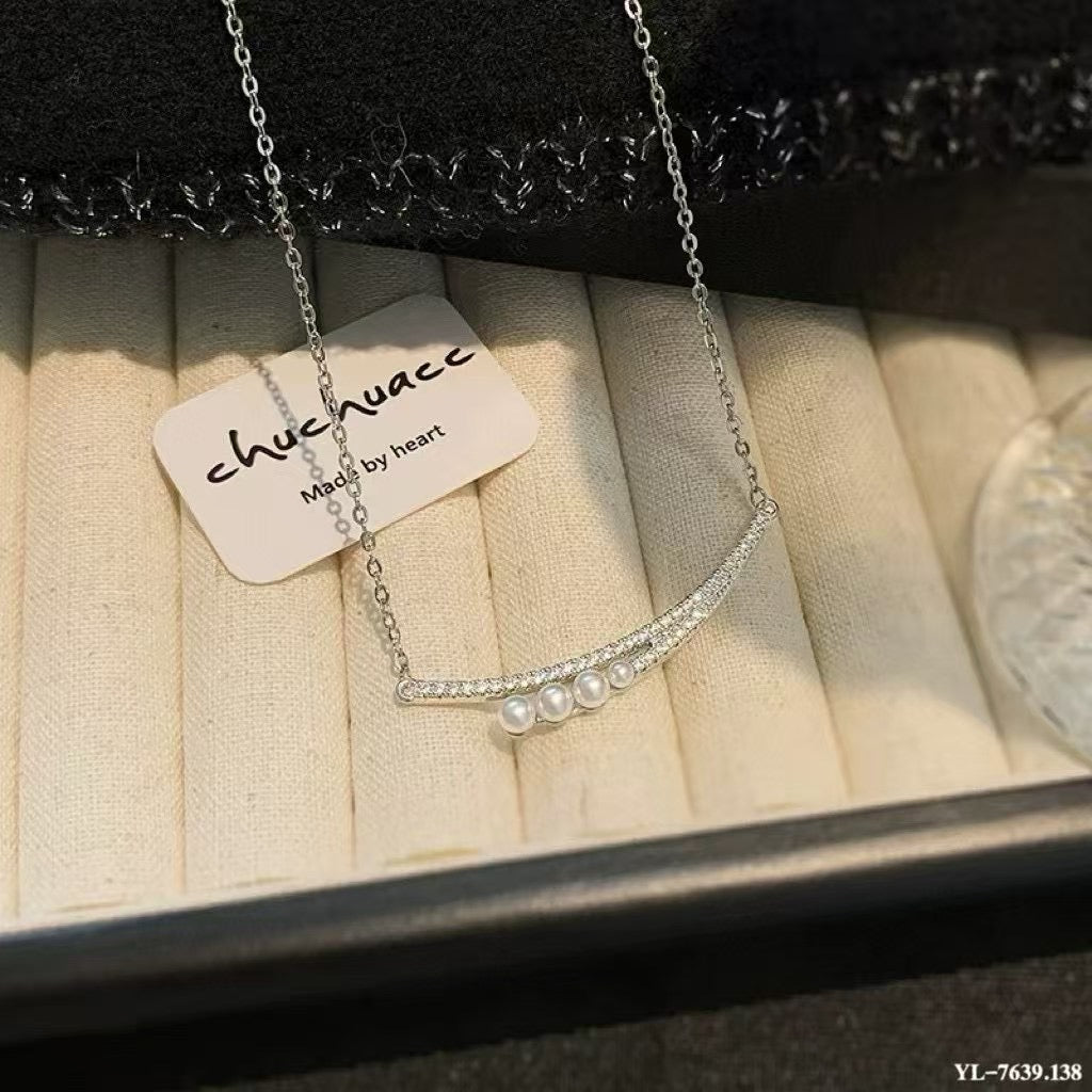 Crescent moon pendant necklace with gradient freshwater pearls in a soft, elegant arrangement.