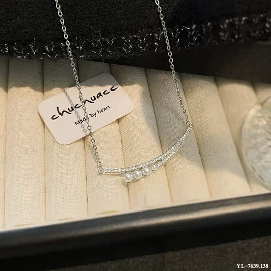 Crescent moon pendant necklace with gradient freshwater pearls in a soft, elegant arrangement.