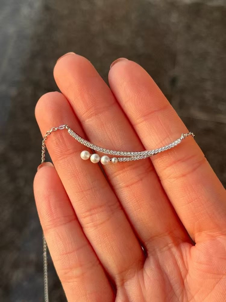 Crescent moon pendant necklace with gradient freshwater pearls in a soft, elegant arrangement.