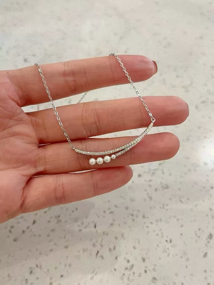 Crescent moon pendant necklace with gradient freshwater pearls in a soft, elegant arrangement.