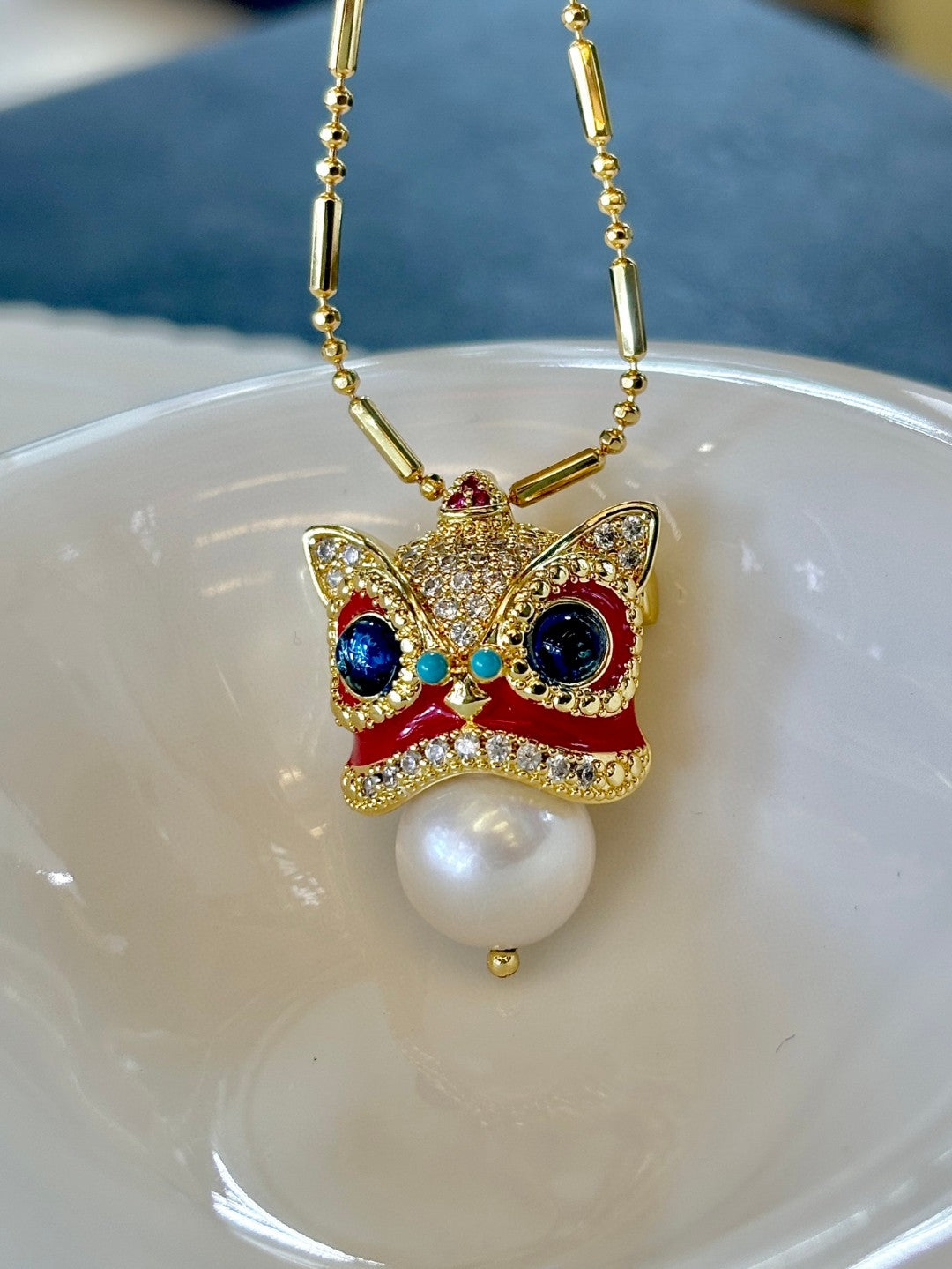 Chinese guardian lion brooch and pendant with Edison pearl, symbolizing luck, prosperity, and elegance.