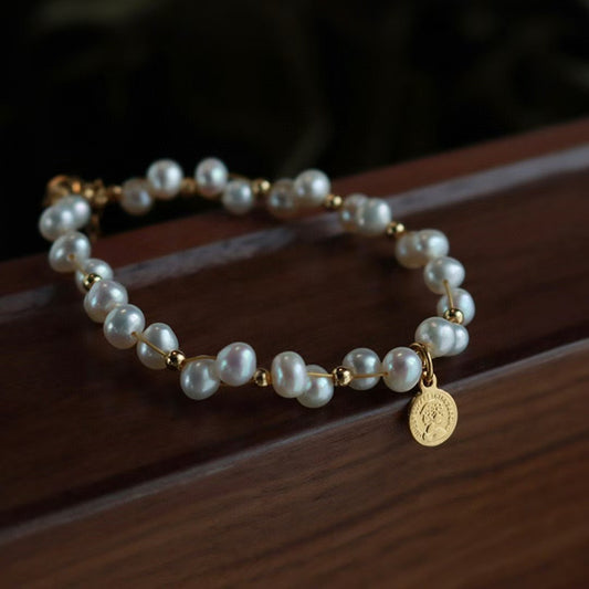 Minimalist freshwater pearl bracelet with round charm and adjustable Japanese woven cord.