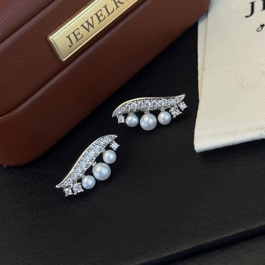 Willow leaf-inspired silver earrings with freshwater pearl accents