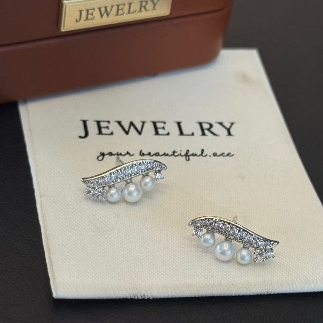 Willow leaf-inspired silver earrings with freshwater pearl accents
