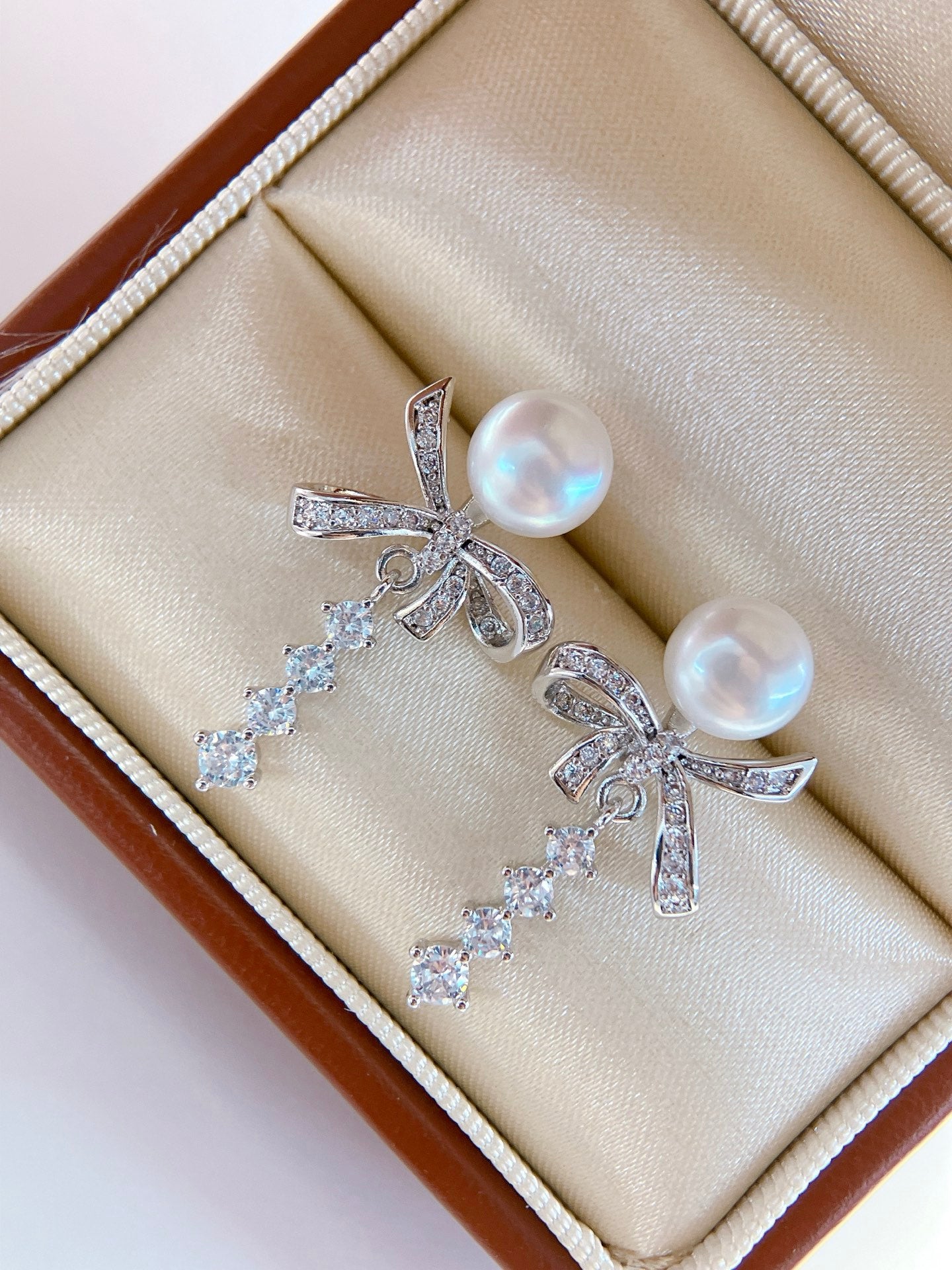 Model wearing silk ribbon bow pearl stud earrings
Close-up of freshwater pearl bow stud earrings