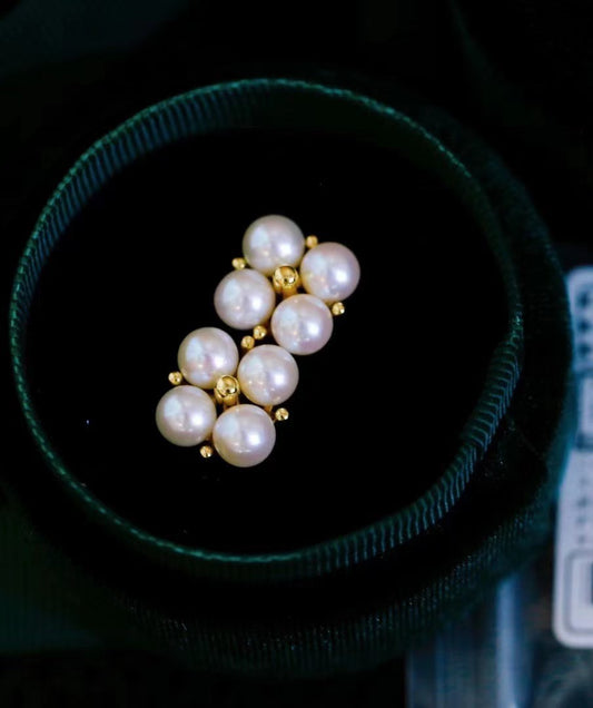 Close-up of four-leaf clover earrings with small freshwater pearls