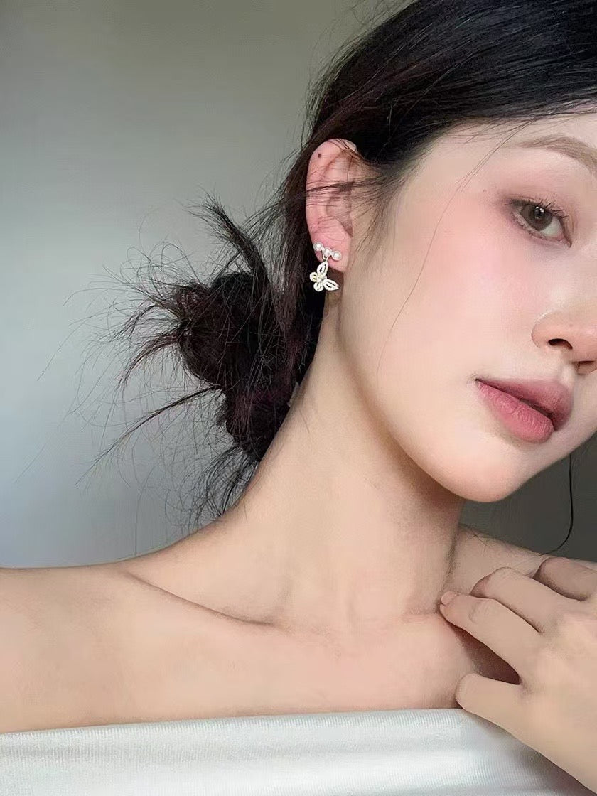 Model wearing elegant butterfly pearl stud earrings