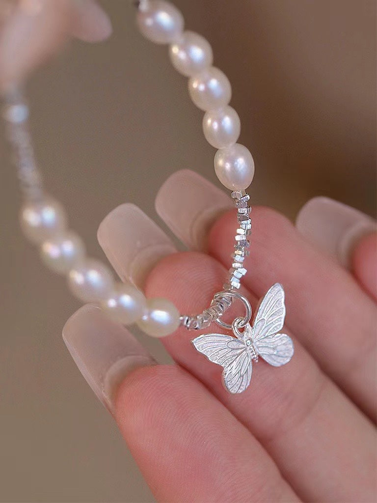 Close-up of freshwater pearls and poetic butterfly charm