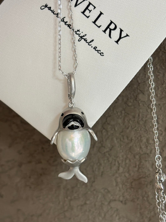 Chubby seal pendant holding a round Edison pearl on white background