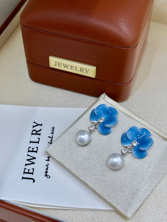 Blue porcelain floral stud earrings with 8mm freshwater pearls on white background