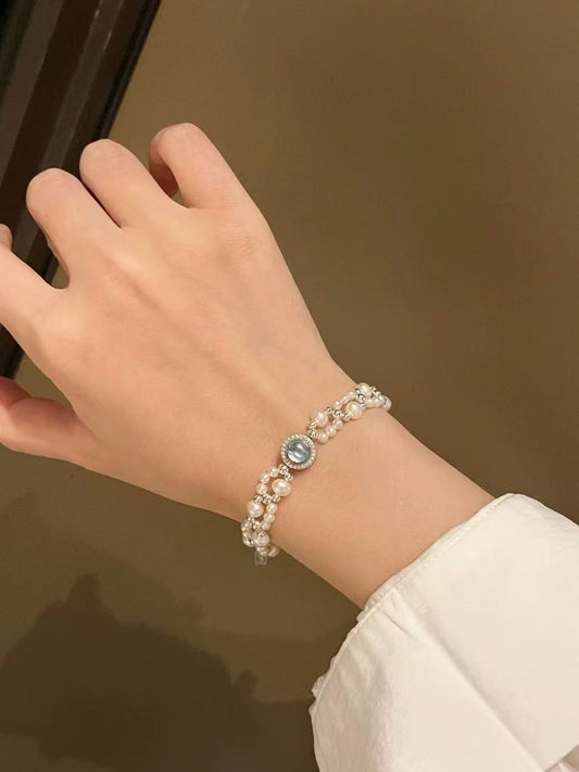 Model wearing ocean-inspired pearl and aquamarine bracelet