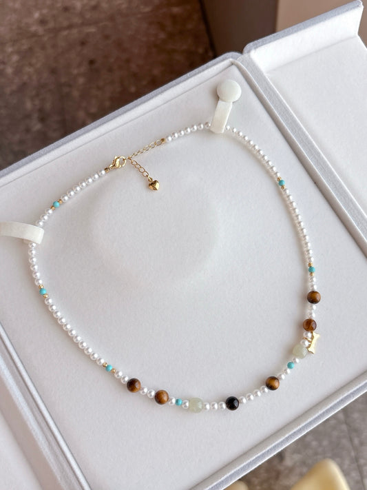 Multicolor freshwater pearl necklace with raw stone accents on white background