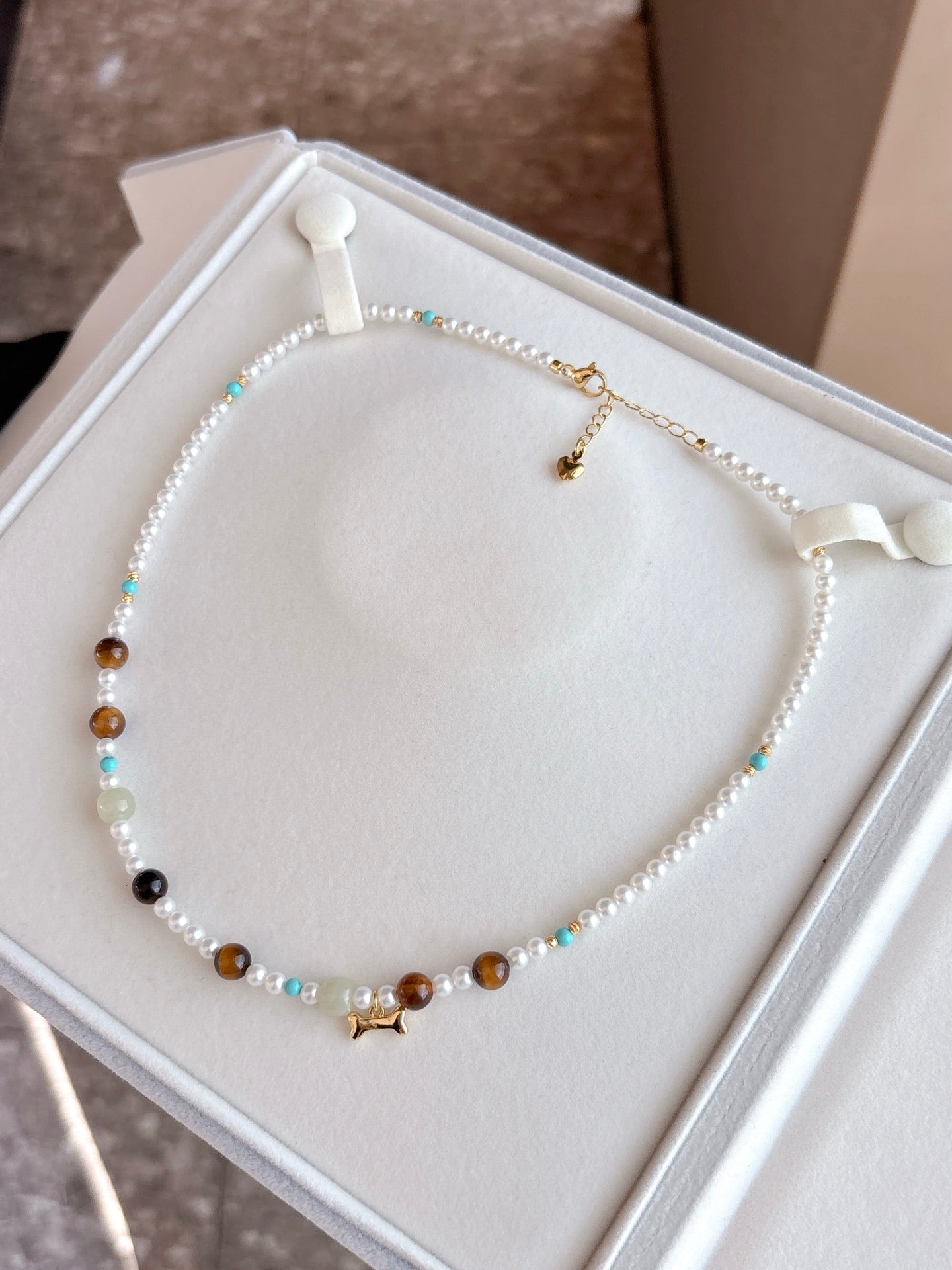 Multicolor freshwater pearl necklace with raw stone accents on white background