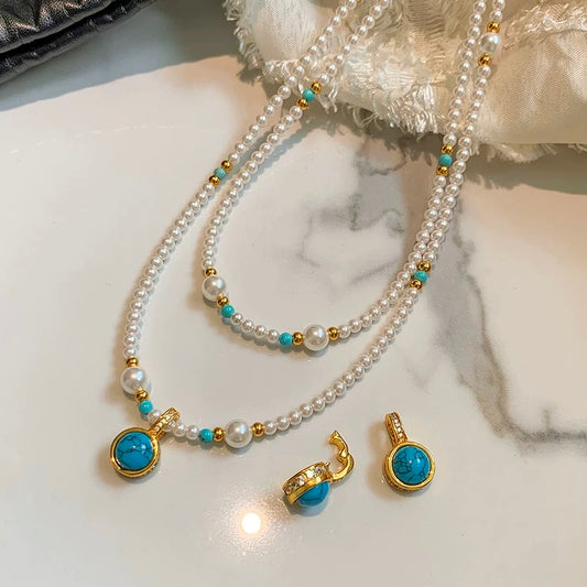 Close-up of a baby pearl necklace with 3–4mm freshwater pearls and a gold-filled charm pendant featuring a universal clasp.