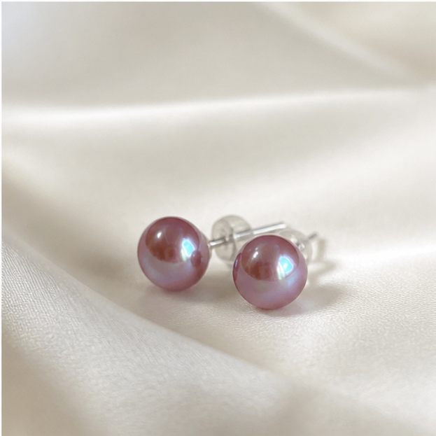 Pair of lavender freshwater button pearl stud earrings on pearl-grey silk