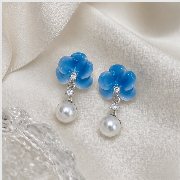 Pair of blue ice porcelain blossom freshwater pearl stud earrings on pearl-grey silk